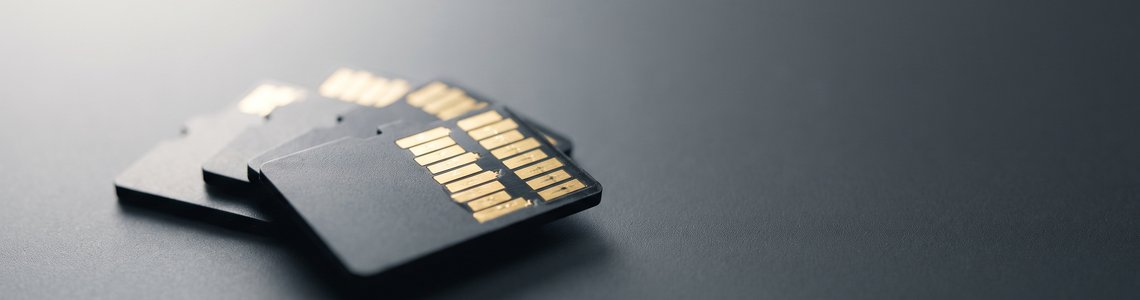 Mehrere unbedruckte microSD-Karten fächerförmig auf einer dunkelgrauen Arbeitsfläche