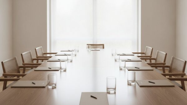 mietpreisbremse 2026 bild 4 Leerer heller Sitzungsraum mit langem Holztisch und unbedruckten Aktendeckeln