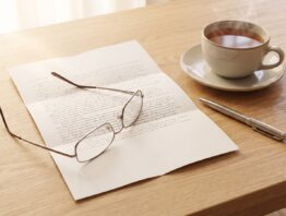 Aufgeschlagene Renteninformation mit Lesebrille auf dem Tisch