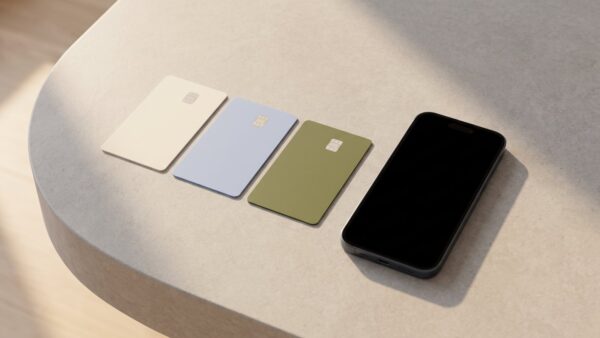 Drei unbedruckte Bezahlkarten und ein Smartphone auf einem Steintisch – Symbol für drei NFC-Betrugsmaschen