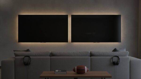 Zwei ausgeschaltete Fernseher nebeneinander ueber einem Sofa mit Kopfhoerern und Football