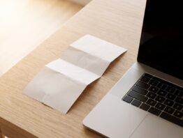 Kassenbon mit Guthabencode neben dem Laptop