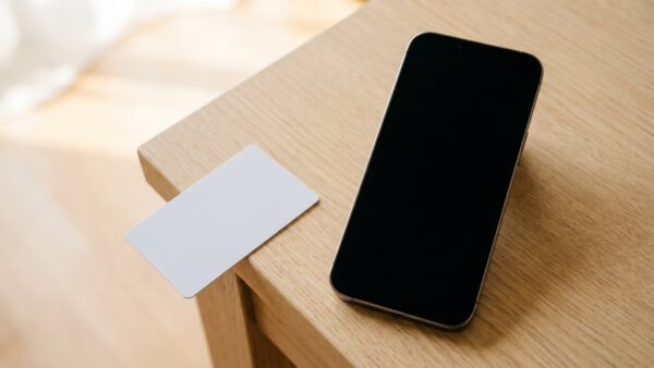 penny app bild 1 Smartphone mit schwarzem Bildschirm neben unbedruckter Plastikkarte