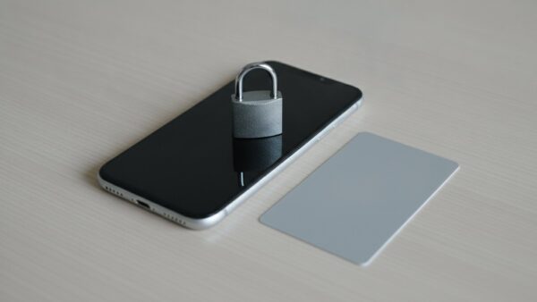Vorhängeschloss auf einem Smartphone neben einer unbedruckten Karte