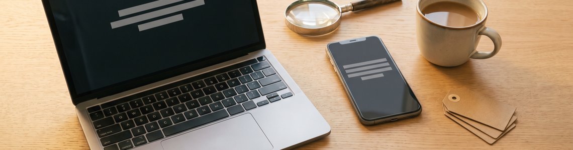 Preisfehler finden: Notebook, Lupe und Preisschilder auf dem Schreibtisch