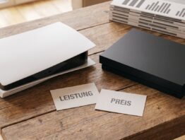 PS5 oder Xbox: zwei Spielkonsolen nebeneinander mit den Karten Leistung und Preis