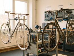 Zwei Fahrräder nebeneinander in einer Werkstatt, eines aufbereitet, eines mit Gebrauchsspuren