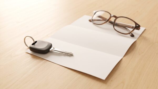 regionalklassen 2027 bild 1 Autoschlüssel, leerer Briefbogen und Lesebrille auf hellem Holztisch