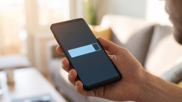 Smartphone in der Hand mit Fortschrittsbalken eines Software-Updates auf dem Display