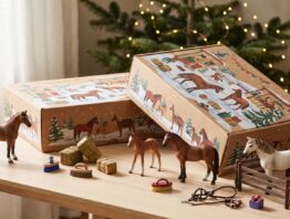 Zwei Schleich Adventskalender 2026 mit Pferdefiguren und Zubehör auf einem Holztisch