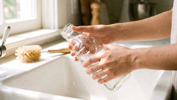 Sprudlerflasche wird von Hand mit einer Bürste gereinigt