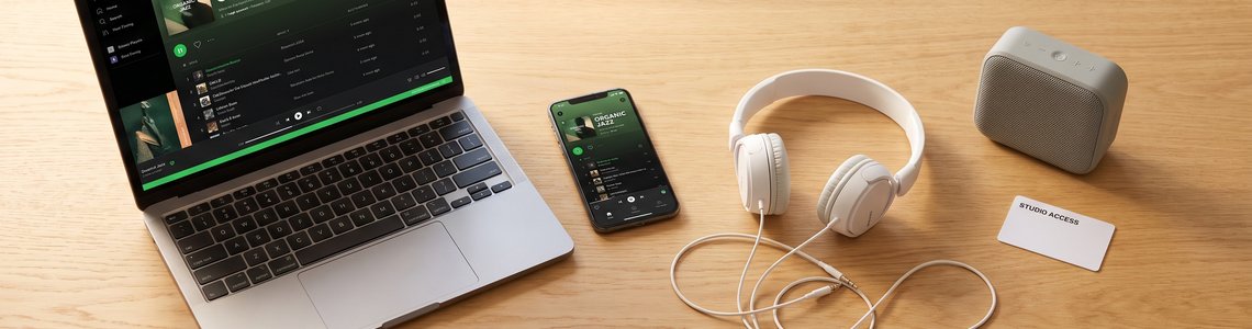 Spotify Login 2026: Laptop, Smartphone und Kopfhörer auf einem Schreibtisch