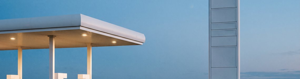 Schlichte Tankstelle in der Abenddämmerung mit leerem Preismast und unbedruckten Zapfsäulen