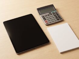 Geschlossenes Notebook mit Taschenrechner und leerem Notizblock