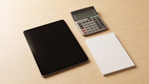 Geschlossenes Notebook mit Taschenrechner und leerem Notizblock
