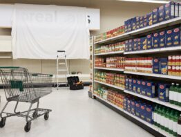 tegut edeka bild 1 Einkaufswagen im Supermarktgang vor einem abgedeckten Ladenschild beim Schilderwechsel