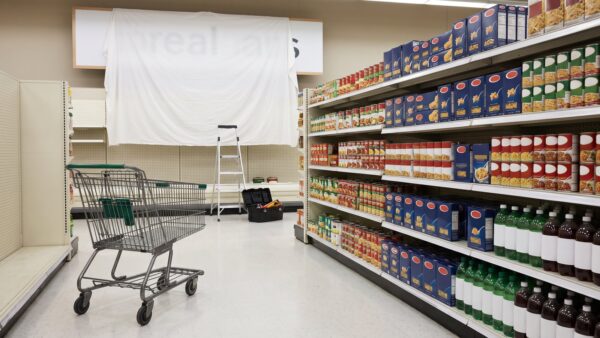 tegut edeka bild 1 Einkaufswagen im Supermarktgang vor einem abgedeckten Ladenschild beim Schilderwechsel