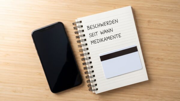 Notizen zur Vorbereitung des Telefonats neben Karte und Smartphone
