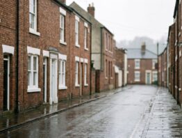Englische Straßenzeile mit Backsteinhäusern und nassem Gehweg nach dem Regen