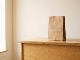 Leere helle Ladentheke mit einer unbedruckten Papiertüte
