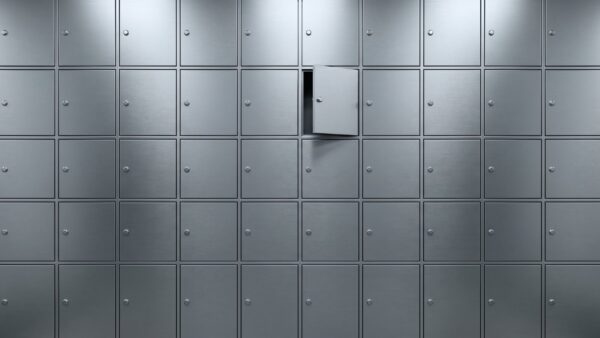 Wand aus gleich großen unbeschrifteten Metalltüren, eine davon einen Spalt geöffnet