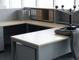Zwei benachbarte Arbeitsplätze im Großraumbüro, einer davon leer geräumt