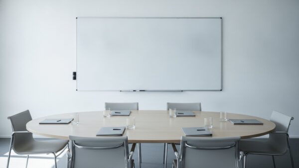 versetzung arbeitsrecht bild 3 Leerer Besprechungstisch mit unbeschrifteten Mappen und leerer Wandtafel im Hintergrund