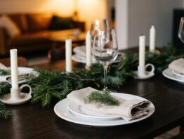 Gedeckter Weihnachtstisch mit Tellern, Kerzen und Tannenzweigen