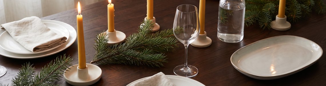 Festlich gedeckter Weihnachtstisch mit Kerzen und Tannenzweigen