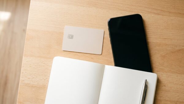 wero bezahlen bild 2 Bankkarte ohne Aufdruck neben Smartphone und Notizblock