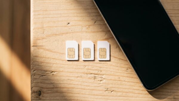wunschrufnummer bild 2 Drei SIM-Karten nebeneinander neben einem Smartphone