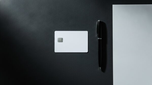 zalando plus bild 4 Leere weiße Plastikkarte neben einem gefalteten Blatt Papier auf dunkler Tischplatte