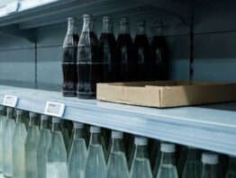 Fast leerer Fachboden mit wenigen Colaflaschen im Getränkeregal eines Discounters