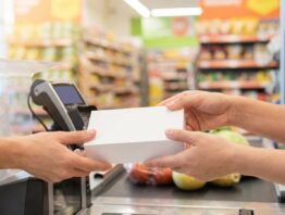 Smartphone-Karton wird an der Supermarktkasse über das Kassenband gereicht