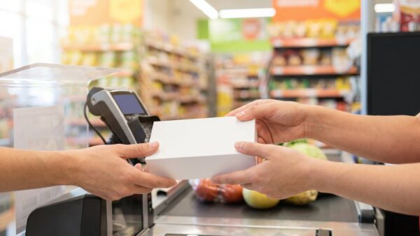 Smartphone-Karton wird an der Supermarktkasse über das Kassenband gereicht