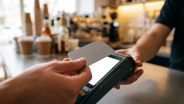 berliner volksbank neukundenbonus bild 1 Hände halten eine Bankkarte kontaktlos an ein Kartenterminal