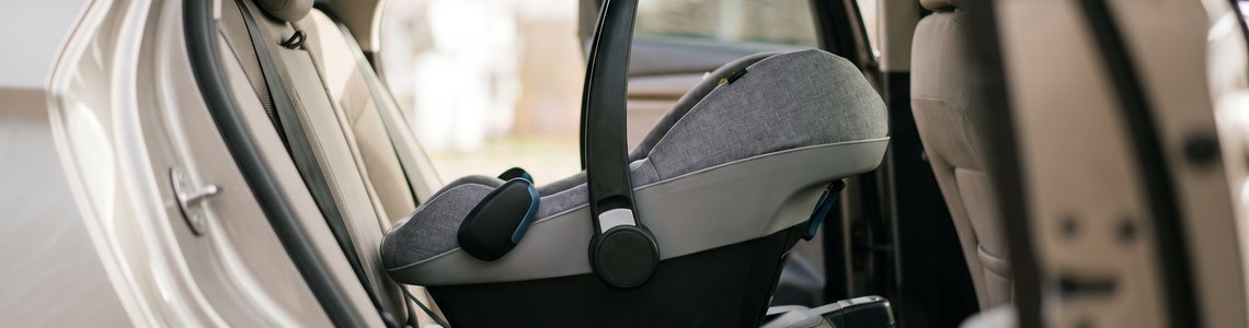 Leere Babyschale auf einer Isofix-Basisstation auf der Rückbank eines Autos