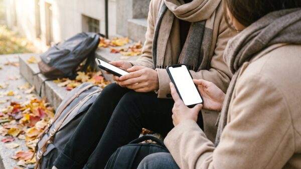 congstar aktion bild 1 Zwei junge Leute mit Smartphones auf einer Treppe vor der Hochschule im Herbst