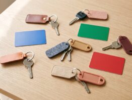 Verschiedene Schlüssel an bunten Anhängern und leere Plastikkarten auf einem Holztisch