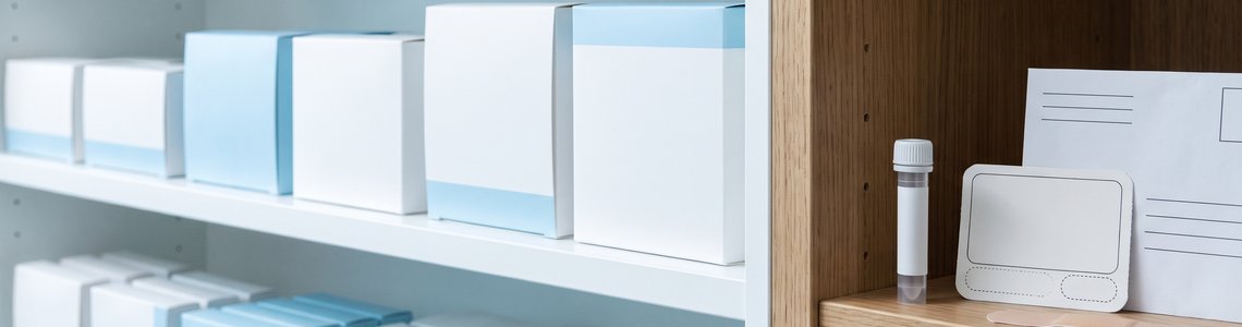 Drogerie-Regal mit Gesundheits-Selbsttests, davor Laborröhrchen, Testkarte und Rücksendeumschlag