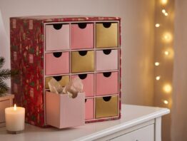 Adventskalender mit zwölf Schubladen in Rosa und Gold auf einem Schminktisch