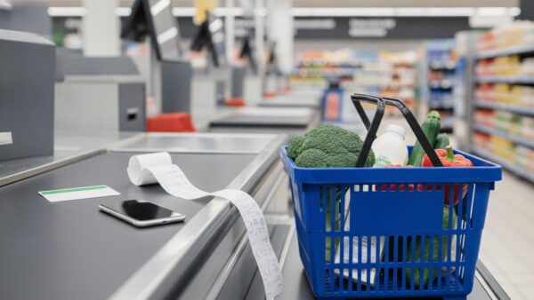 Aufladekarte, Kassenbon und Smartphone auf dem Kassenband im Supermarkt
