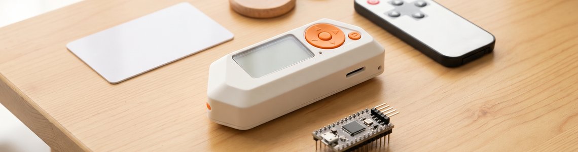 Kleines weißes Multitool-Gadget neben Zugangskarte, Schlüsselanhänger und Fernbedienung auf einem Holztisch