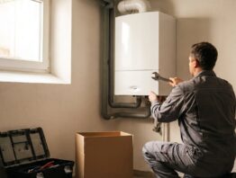 gasheizung bild 1 Installateur montiert eine neue Gasheizung als Brennwertgerät an einer Kellerwand