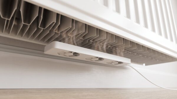 heizkoerperventilator bild 1 Weiße Lüfterleiste mit drei kleinen Ventilatoren magnetisch unter einem Plattenheizkörper befestigt