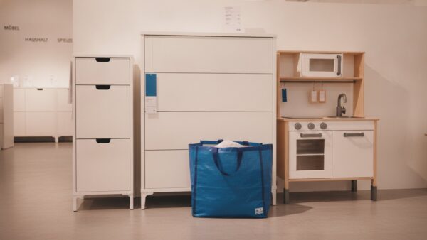 ikea black friday bild 2 Kommode, Schuhschrank und Kinderspielküche mit blauer Einkaufstasche in einer Möbelausstellung
