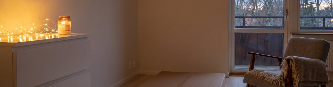 Skandinavisches Wohnzimmer im November mit Kommode, Möbelpaket und Lichterkette