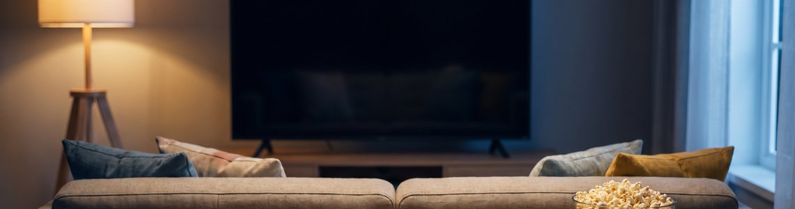 Vier Gamecontroller auf einem Wohnzimmertisch vor dem Sofa als Symbol für einen Koop-Spieleabend
