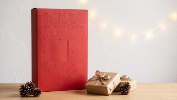 pokemon adventskalender bild 1 Roter Adventskalender mit geschlossenen Türchen und Geschenkboxen auf einem Holztisch