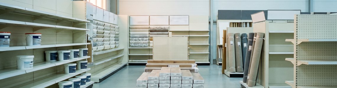 Halb leergeräumter Markt mit Farbeimern, Laminatpaketen und Teppichrollen